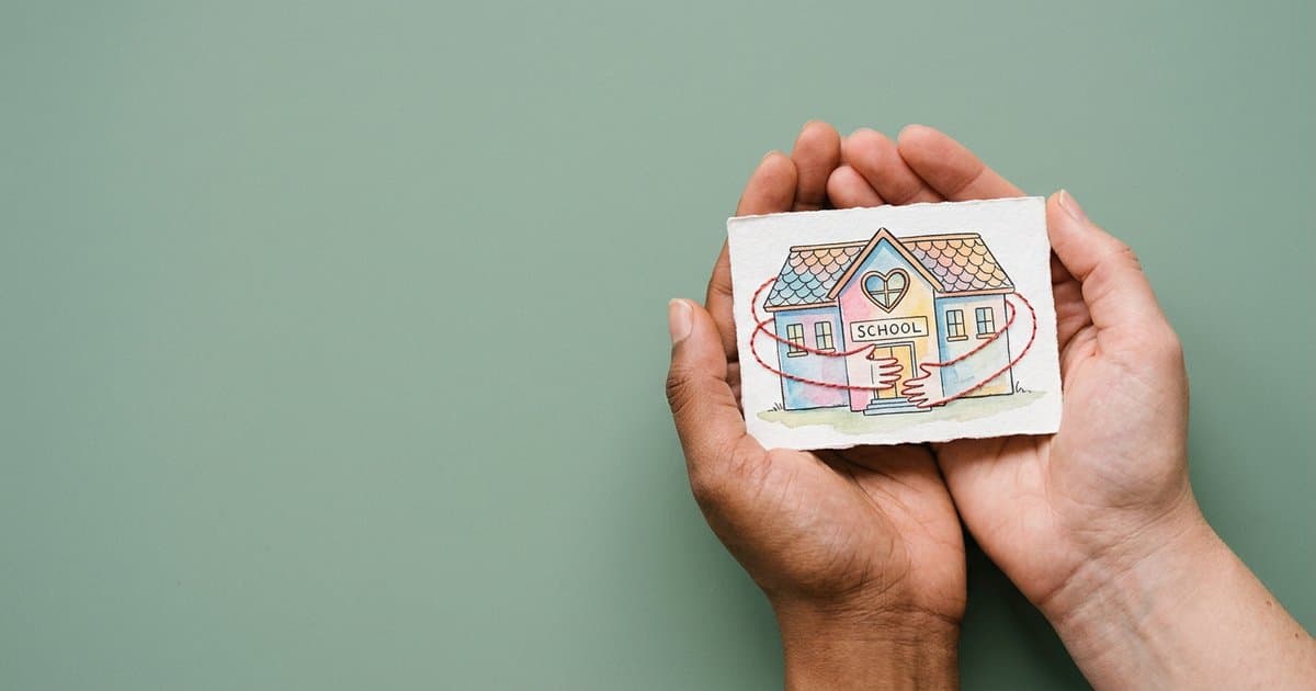 Featured image for Attachment aware schools training: what it means in practice: hands holding a pastel watercolour illustration representing the topic