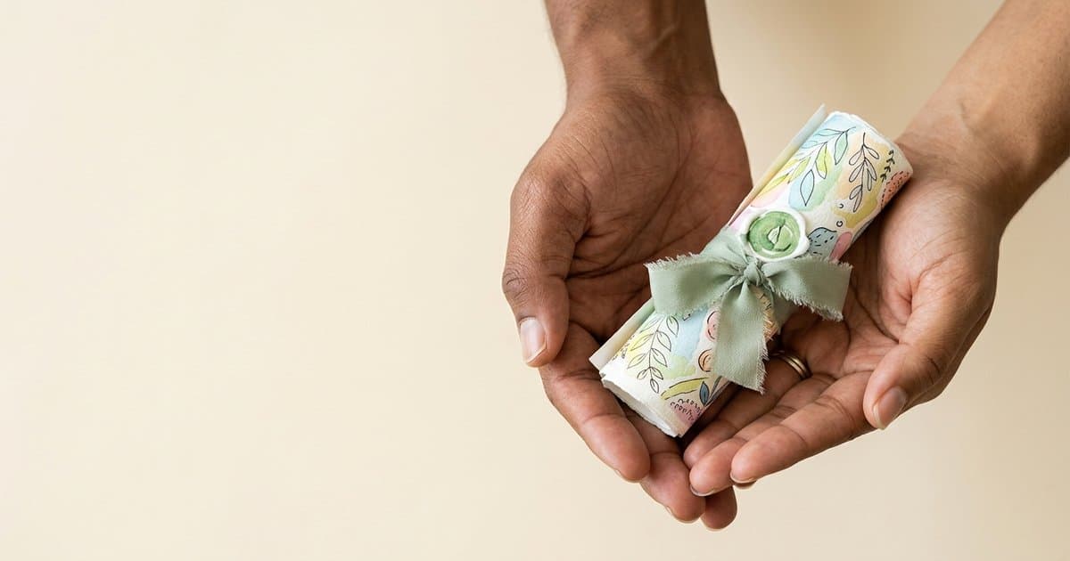 Two pairs of hands cradling a small watercolour scroll tied with a sage green ribbon and a green seal. A symbol of careful, considered training that protects dignity.