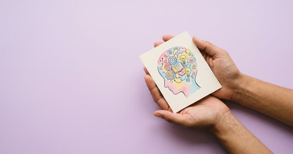 Hands holding an illustrated head with thinking cogs representing metacognitive strategies